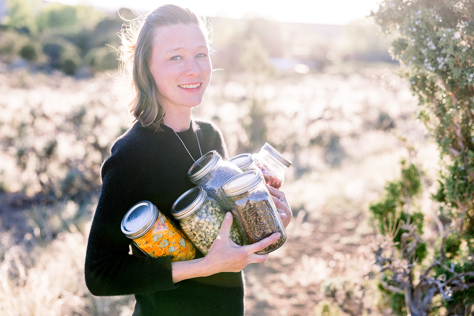 Dr. Shayna Powell holding jars of herbs in the Colorado high country